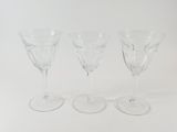 three empty wine glasses sitting next to each other on a white surface
