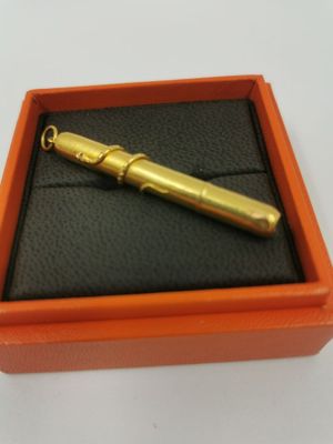une boîte orange contenant un stylo doré
