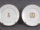 deux assiettes ornées de motifs dorés et blancs, posées sur une table