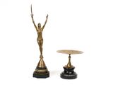 a statue of a woman holding a sword next to a small table