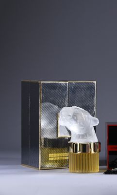 a close up of a bottle of perfume next to a box of perfume