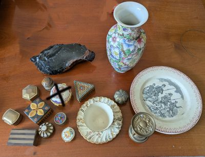 une table sur laquelle se trouvent un vase, des assiettes et d'autres objets