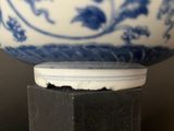a blue and white bowl sitting on top of a wooden stand