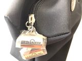 a black bag with a tag on it hanging from it ' s side