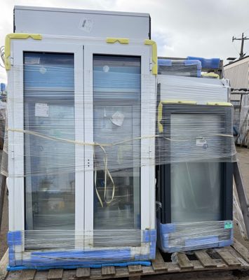 a large stack of windows sitting on top of a pallet