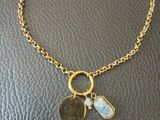 un collier en or orné d'une pièce et de deux breloques