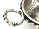 a silver bowl with a ring on top of it