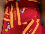 une boîte contenant un t-shirt rouge et une écharpe jaune et rouge