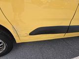 a yellow car that has been dented and is parked in a parking lot