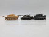 two toy tanks sitting next to each other on a white surface