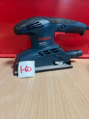 La ponceuse orbitale Bosch est posée sur une table, à côté d'une boîte rouge.