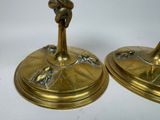 two brass candles that are sitting on top of each other