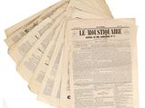 several newspapers are stacked on top of each other on a white surface