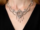 the woman is wearing a necklace that has a lot of diamonds on it