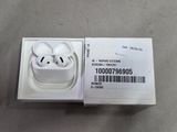 Des AirPods d'Apple sont posés dans une boîte sur une table