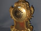a gold clock sitting on top of a table