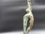 bronze sculpture of a man on a surfboard on a marble base