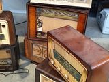 several old radio ' s are stacked on top of each other in a room
