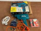 a blue and orange corded drill on a wooden table