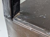 close up of a metal shelf with a black metal frame and a white wall