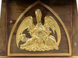 a clock that has a golden bird on it