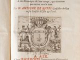 un livre ouvert sur lequel figurent un blason et une couronne