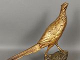 a golden bird sitting on top of a rock