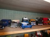 de nombreuses petites voitures et de nombreux petits camions sur une étagère dans une pièce