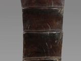 un vieux vase en bois orné d'un motif rayé