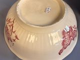 a white bowl with red flowers on it on a table