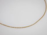 un collier à chaîne en or orné d'une petite perle sur fond blanc