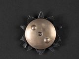 a metal button that has been placed on a black surface