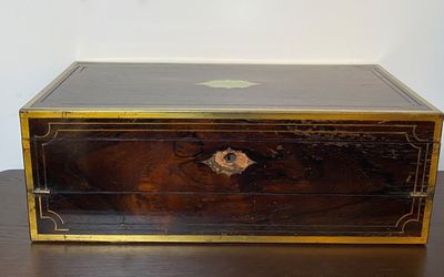 a black and gold box sitting on a wooden table