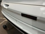 a close up of a white car with a sticker on it ' s bumper
