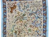 a close up of a blue and white scarf with animals on it