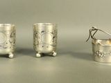 three silver cups sitting on top of a table next to each other