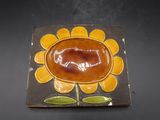 une assiette marron et jaune sur laquelle est représenté un tournesol