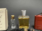 a bottle of perfume next to a box and a necklace