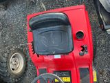 a red toy tractor with a steering and a steering wheel
