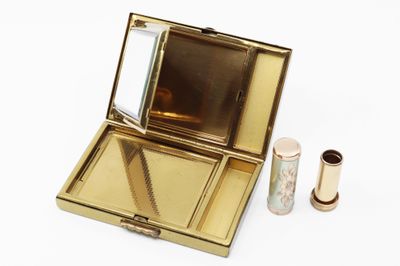une petite boîte en or surmontée d'un miroir