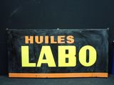 une pancarte indiquant « Hues Labo » à côté d'une poubelle