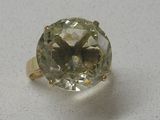 une image représentant une bague ornée d'une pierre verte sur un fond blanc