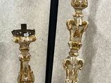two gold candlesticks sitting on a table next to each other