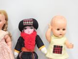 three dolls sitting next to each other on a table