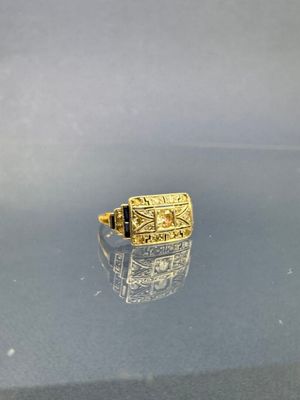 bague en or jaune ornée d'une pierre noire au centre