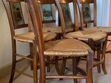 four wooden chairs sitting next to each other on a carpeted floor