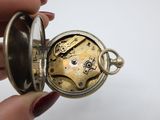 a close up of a person holding a pocket watch