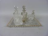 trois bouteilles en verre posées sur un plateau, sur une surface blanche