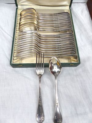 a lot of silver spoons and forks in a case