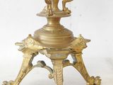 a gold vase sitting on a stand with a bird on it
